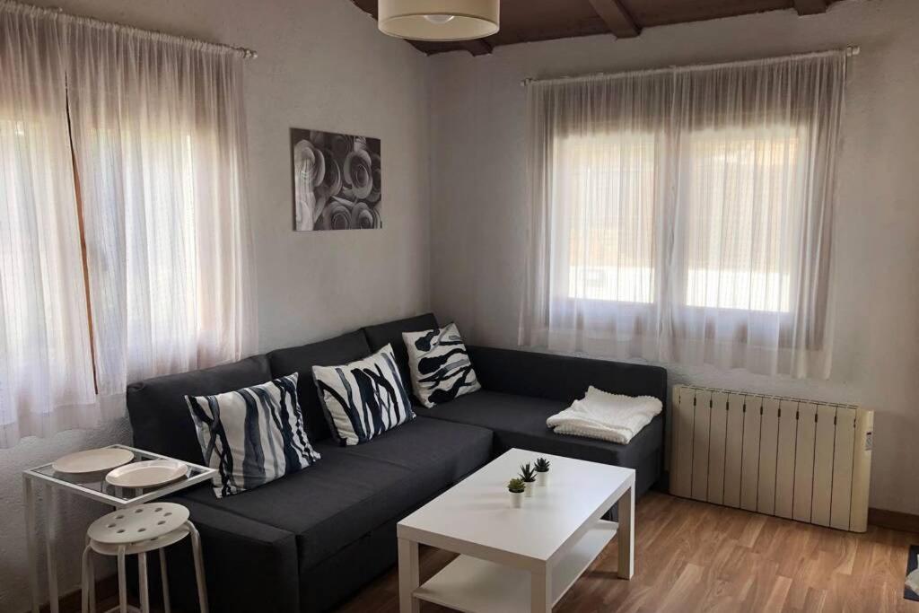 ein Wohnzimmer mit einem Sofa und einem Tisch in der Unterkunft ESTUDIO MAESO in Manzanares el Real