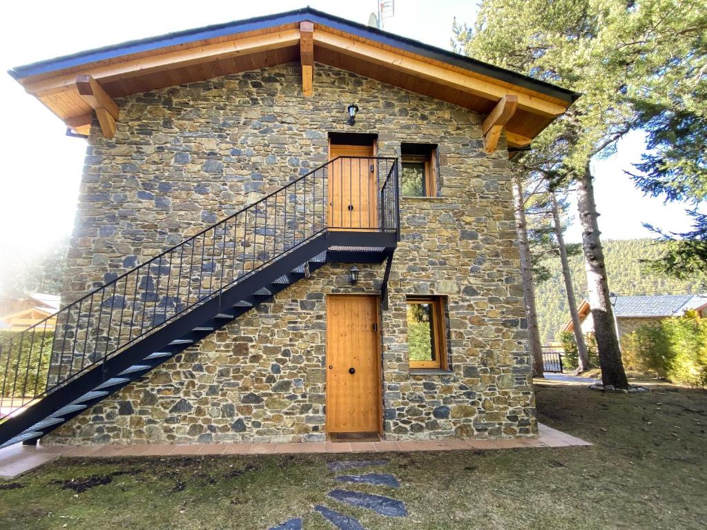 une maison en pierre avec un escalier sur son côté dans l'établissement Casa MARAVILLA 8 pax. Deporte y relax exclusivo!, à La Molina