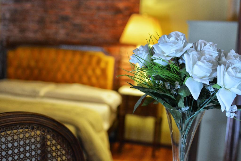 um vaso cheio de flores brancas sentado numa mesa em La Fresque Hotel em Buenos Aires