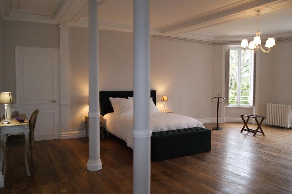 a bedroom with a bed and a pole at Le château de la brosse Chambres d'hôtes in Brinay