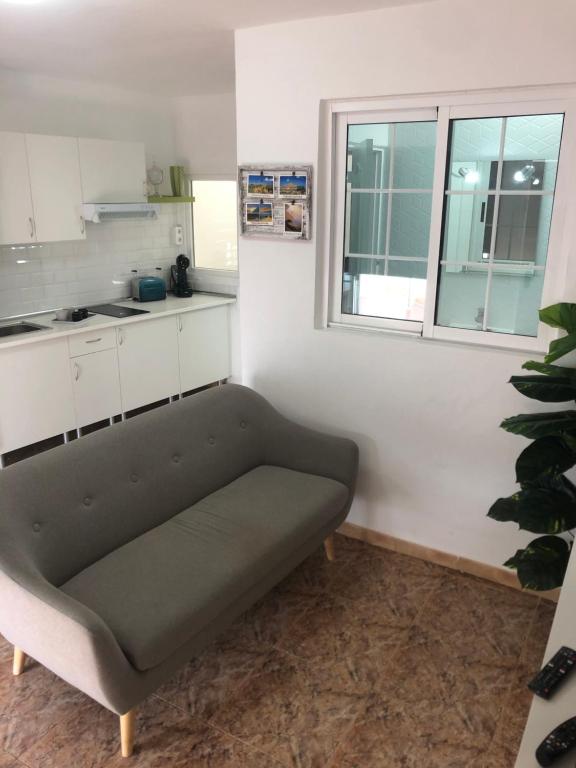 ein Sofa in einem Zimmer mit Küche in der Unterkunft Apartamentos Elena in Lajares