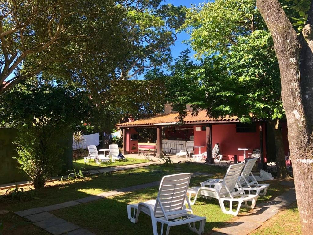 a group of white chairs sitting in a yard at Trip Maresias Suítes in Maresias