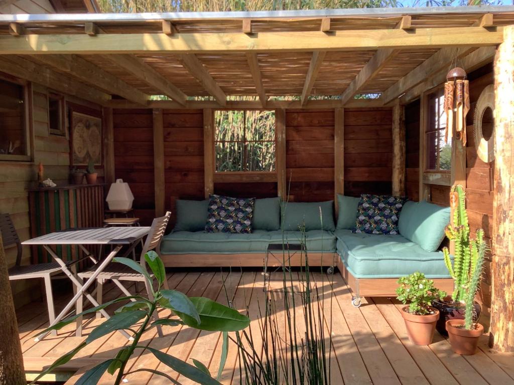 un patio con sofá y una mesa en una terraza en La Cabane d'Arbolateia piscine & SPA, en Bidart