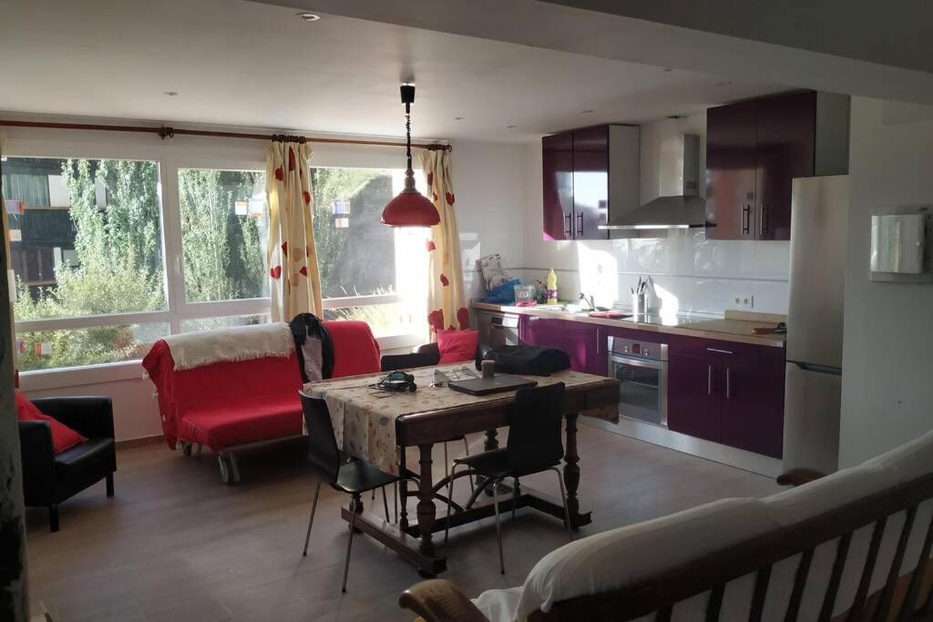 cocina y sala de estar con mesa y sillas en Apartamento T28 Edif Europa y parking gratuito en Sierra Nevada