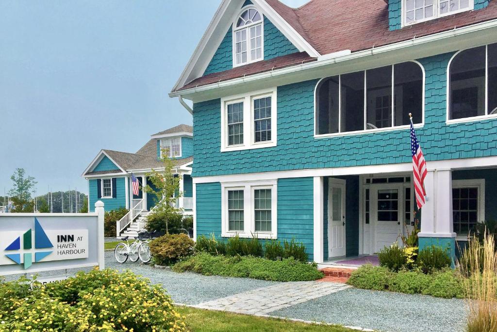 a blue house with a sign in front of it at Inn at Haven Harbour in Rock Hall