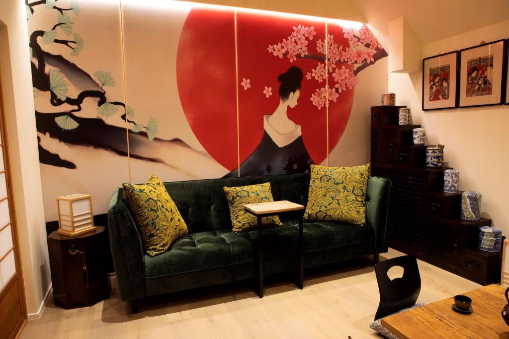 una sala de estar con un sofá verde y una gran pintura en Wabi Sabi B&B en Peer