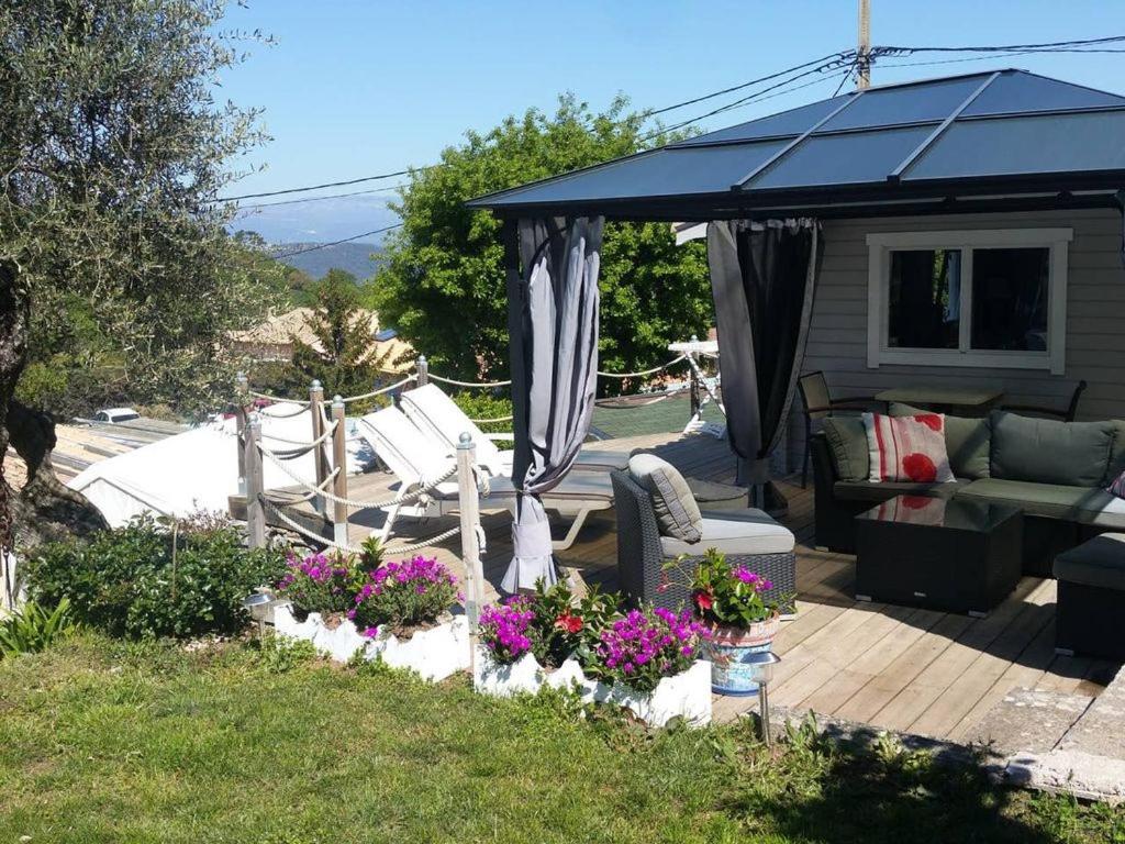 eine Terrasse mit einem Pavillon, Stühlen und Blumen in der Unterkunft Chalet de charme tout confort in Les Adrets-de-l’Estérel