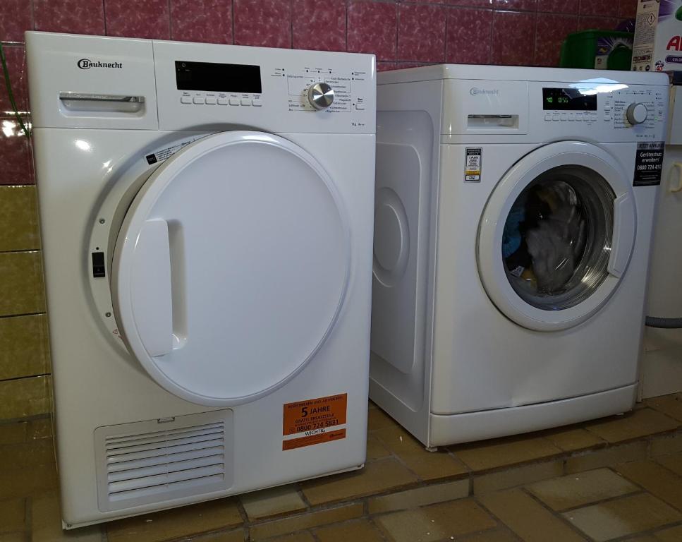 uma máquina de lavar roupa e uma máquina de secar ao lado uma da outra em Monteur Apartment Victoria em Hagen