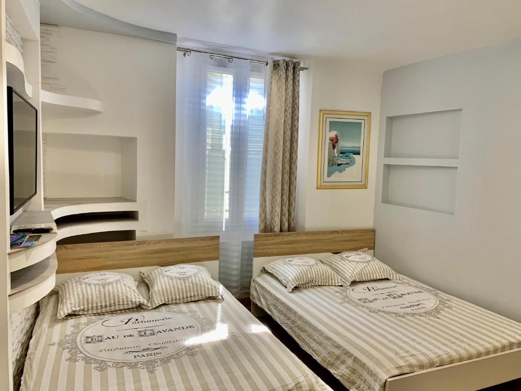 a bedroom with two beds and a window at Excellent Studio au cœur historique de Fréjus in Fréjus