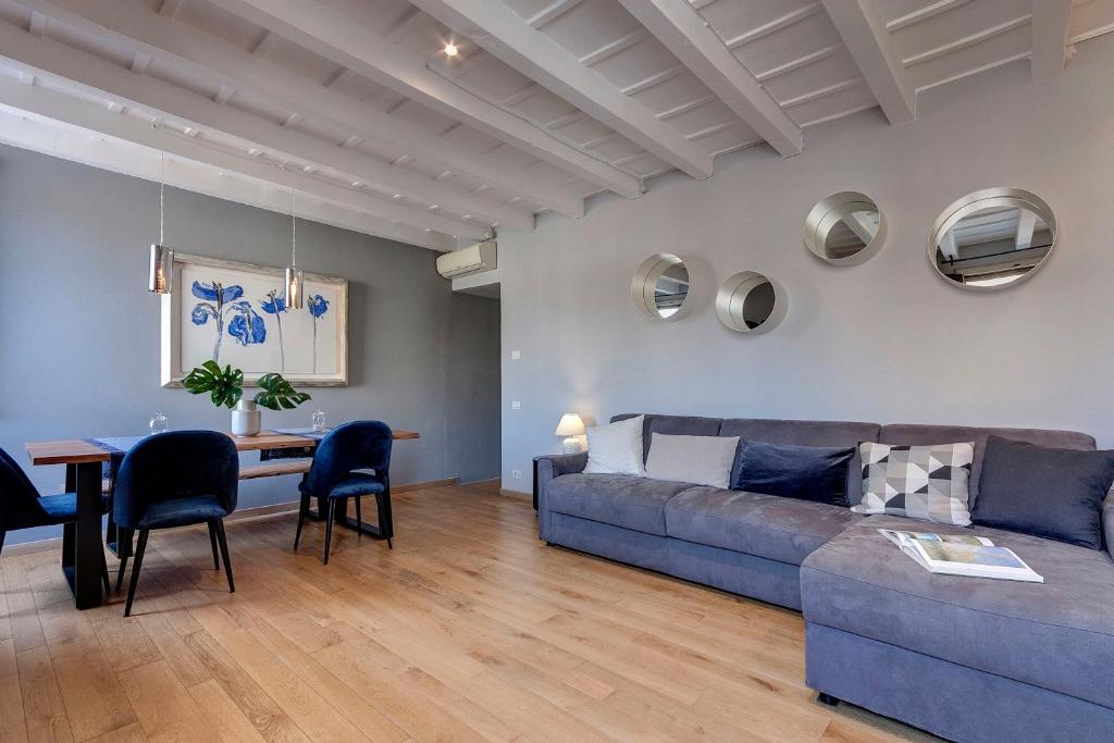 ein Wohnzimmer mit einem blauen Sofa und einem Tisch in der Unterkunft Mamo Florence - San Marco Apartment in Florenz