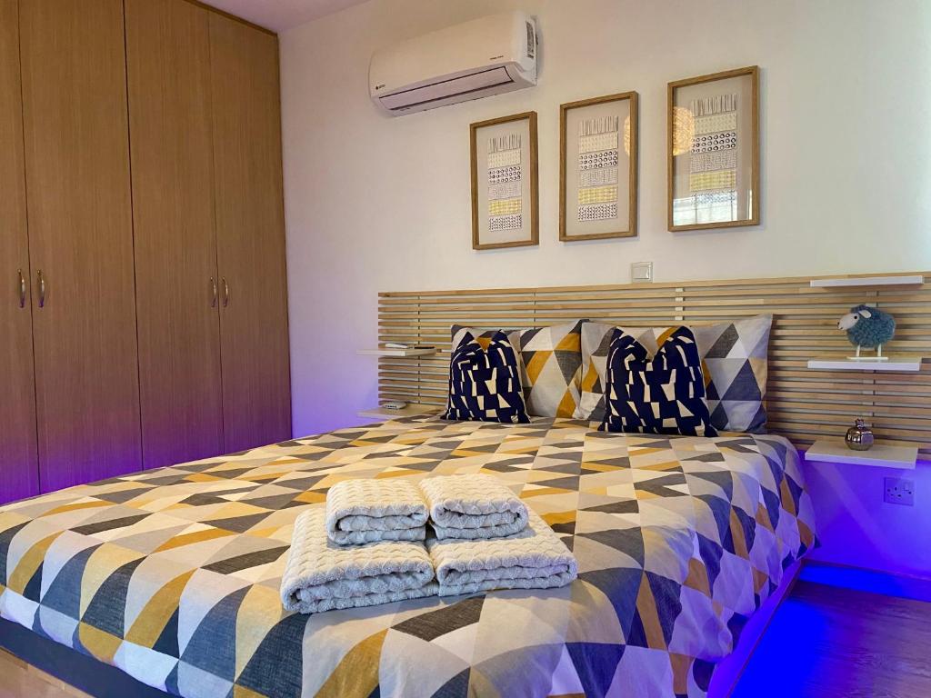 a bedroom with a bed with two towels on it at Fat Cow Apartment 103 in Larnaka