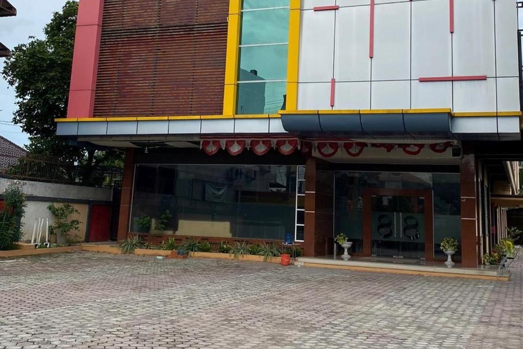 un magasin devant un bâtiment avec beaucoup de fenêtres dans l'établissement RedDoorz Plus Syariah @ Jalan Syiah Kuala Banda Aceh, à Lheue