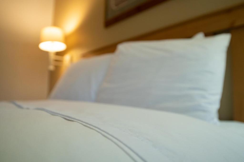 a close up of a bed with a white pillow at Cold Creek Inn in Mount Shasta