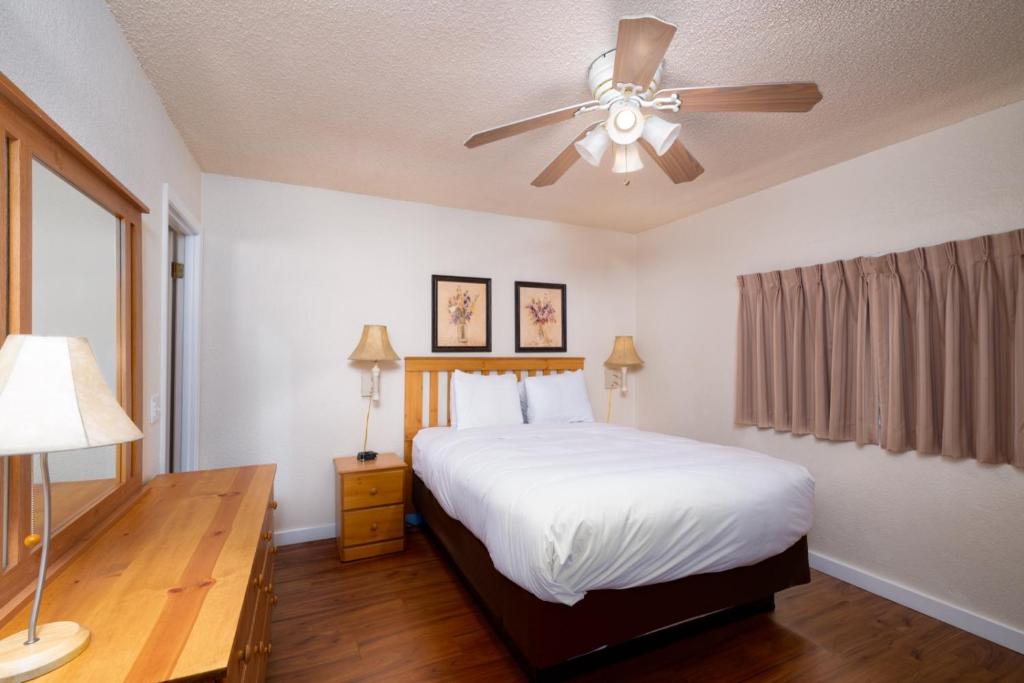 Cold Creek Inn في جبل شاستا: غرفة نوم بسرير ومروحة سقف