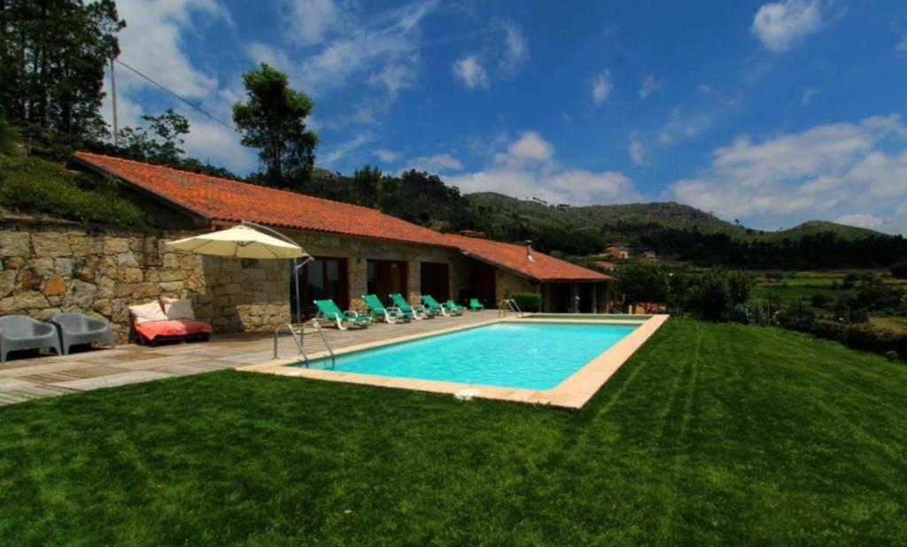 a swimming pool in the yard of a house at Casa dos Cinco - Gerês in Terras de Bouro