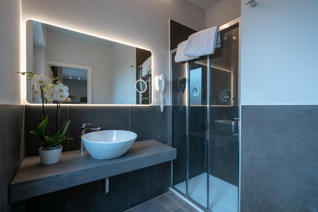 uma casa de banho com um lavatório e uma cabina de duche em vidro. em Appartamenti Astoria em Bolonha