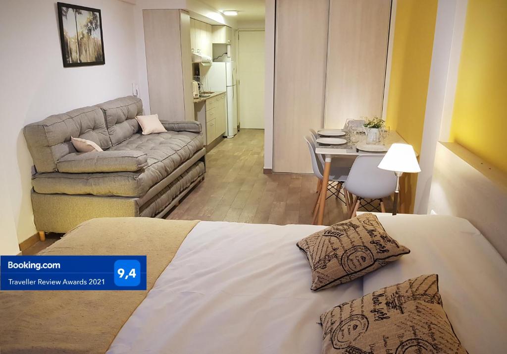 Zimmer mit einem Bett, einem Sofa und einem Tisch in der Unterkunft Bariloche Apart in San Carlos de Bariloche