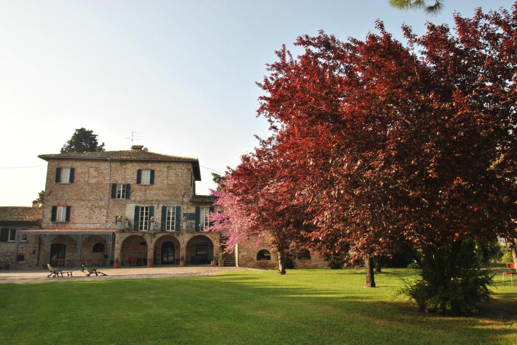 een groot gebouw met een boom ervoor bij B&B Villa Dei Priori in Monsampolo del Tronto