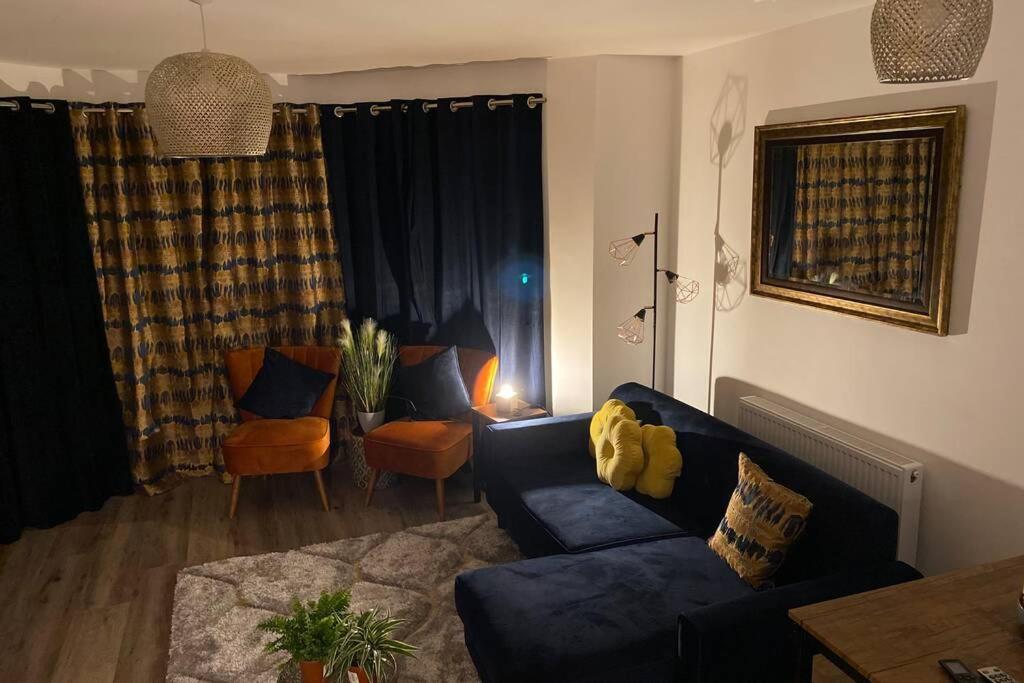 sala de estar con sofá azul y mesa en Luxury Modern 2Bed Seafront Apartment in Rhos on Sea, en Colwyn Bay