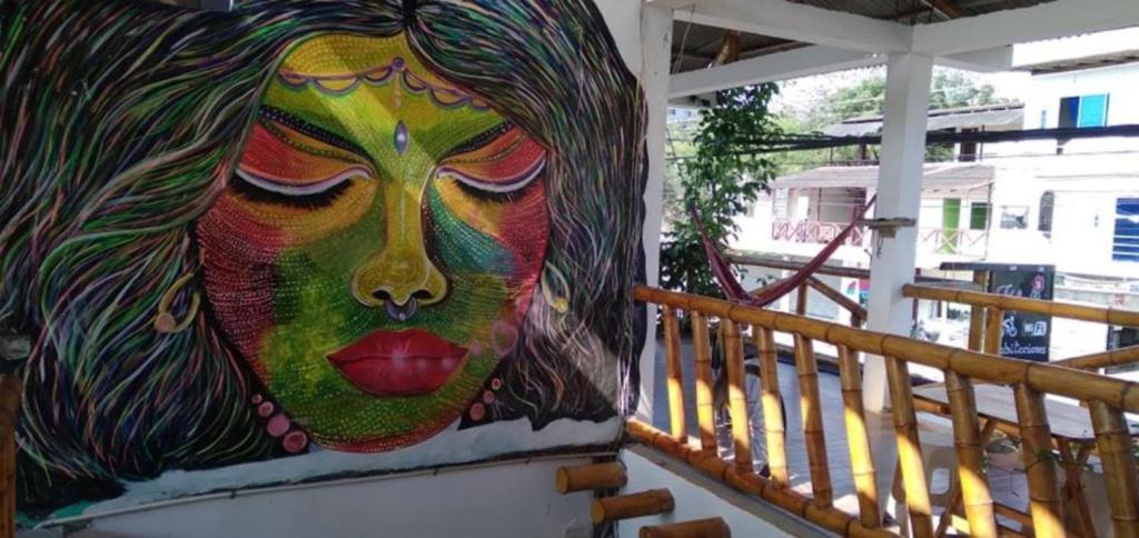 uma pintura de uma mulher ao lado de um edifício em Casa Mafer Lodge em Montañita