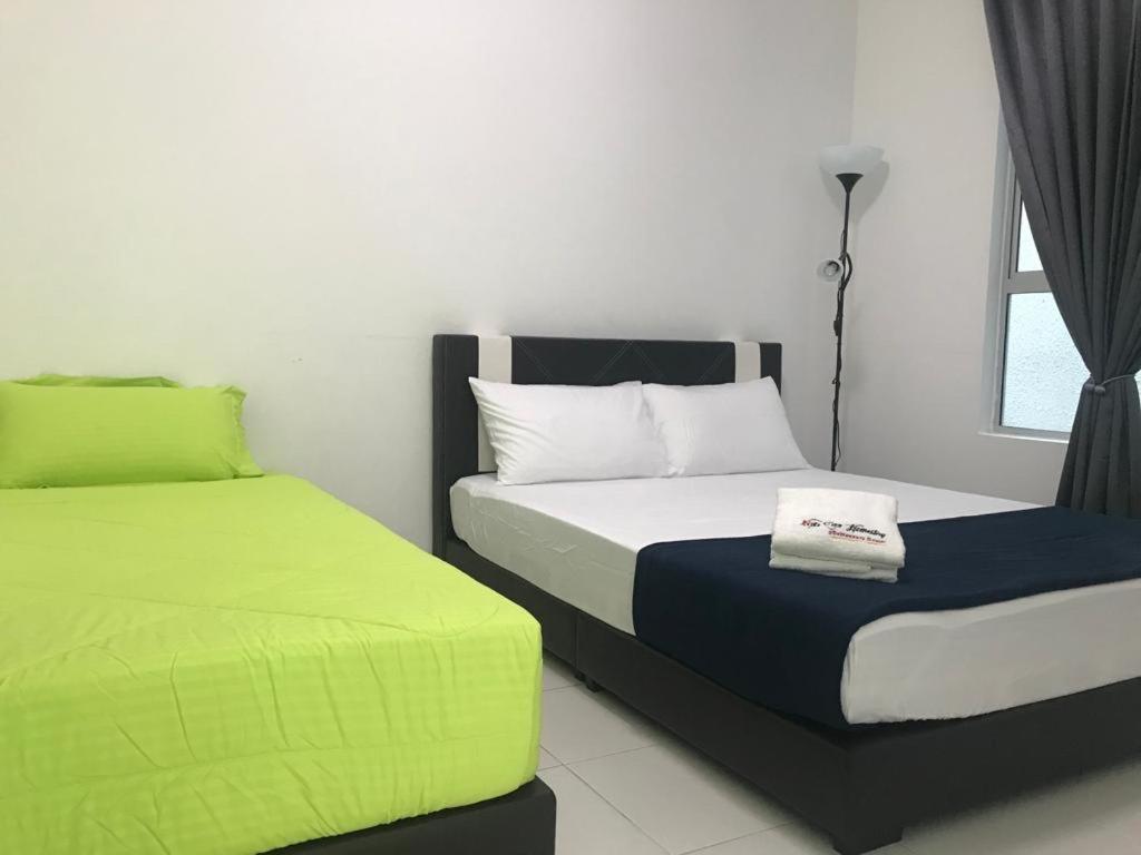 a bedroom with two beds with green and white at The Zizz Homestay@Damansara Damai in Petaling Jaya