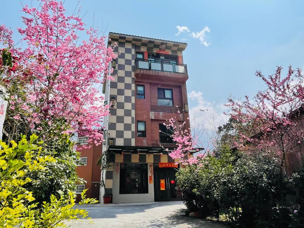 鹿谷的住宿－新景宏渡假村，前面有粉红色花卉的建筑