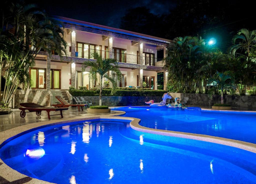 una piscina di fronte a un edificio di notte di Hotel Amira a Carrillo