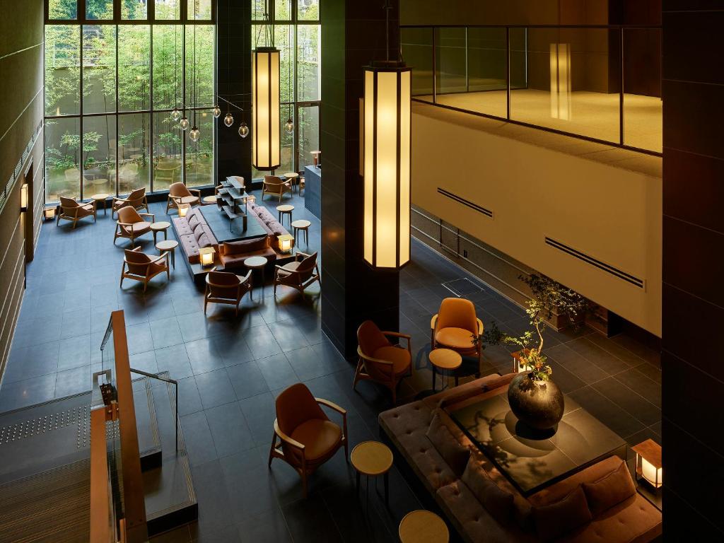 a lobby with a table and chairs and a large window at Hotel The Celestine Kyoto Gion in Kyoto