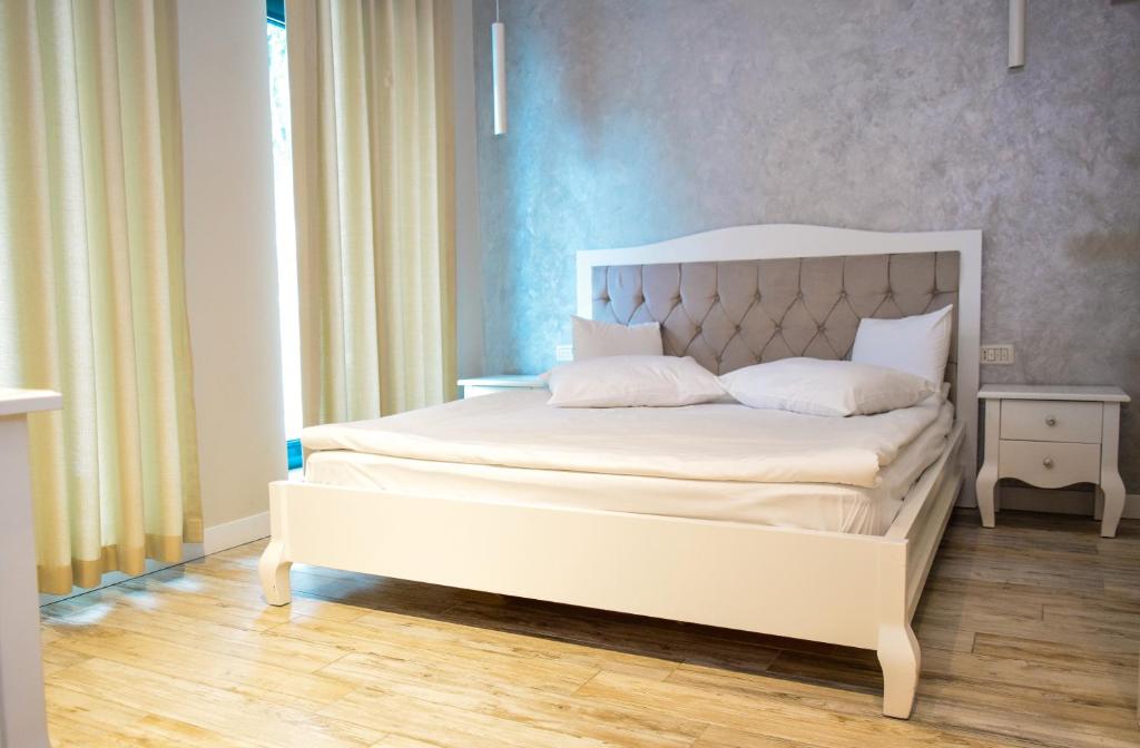 a bedroom with a white bed with a white headboard at Camere de Inchiriat IGLOO in Predeal