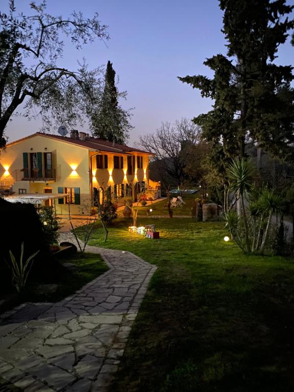uma casa com jardim à noite em Holiday house CuordiNatura em Montopoli in Val dʼArno