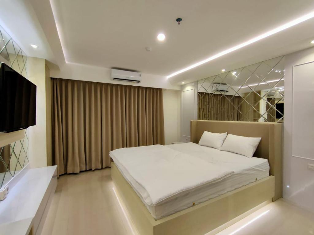 a bedroom with a large bed and a television at Platinum 1012 Studio Tera Apartemen Bandung City View in Bandung
