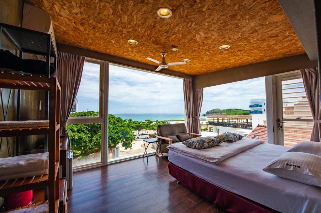 a bedroom with a bed and a large window at Mahalo B&B in Magong