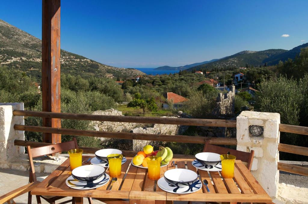 uma mesa de madeira com comida em cima de uma varanda em House of Joy with 3 bedrooms and great views em Ayia Evfimia