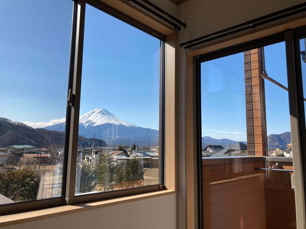 y ventanas con vistas a una montaña cubierta de nieve. en Furaku-Poodle, en Fujikawaguchiko