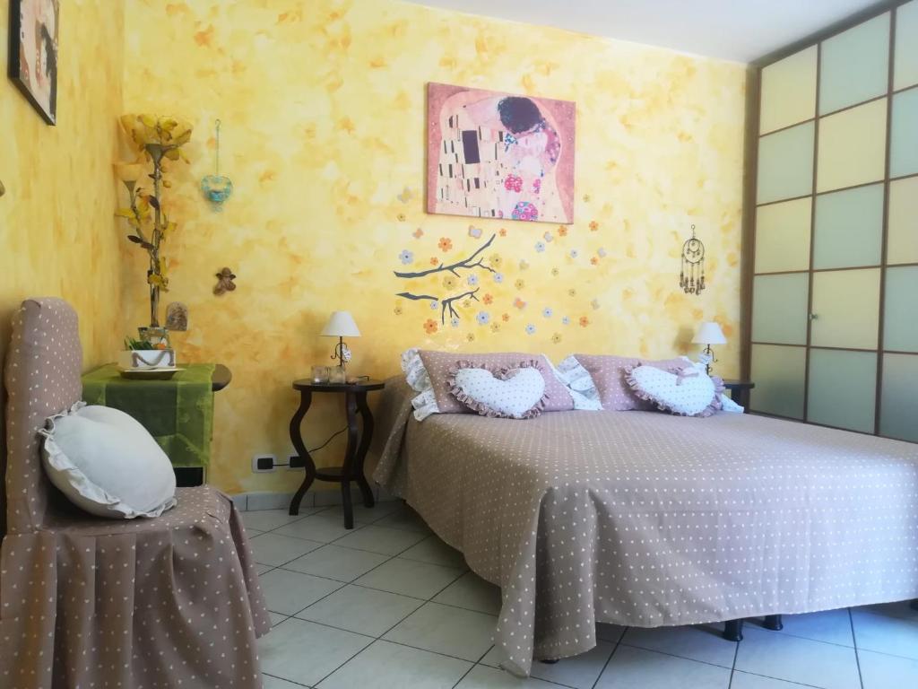 een slaapkamer met een bed en een gele muur bij Antoinette in Gaeta