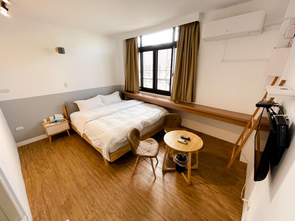 Habitación pequeña con cama y mesa en Small Island Homestay en Tainan
