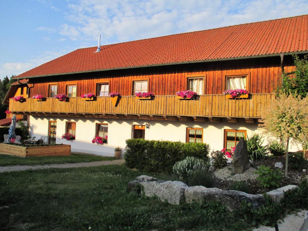 une maison avec un toit rouge et des fleurs dans l'établissement Bärenhof, à Tirschenreuth