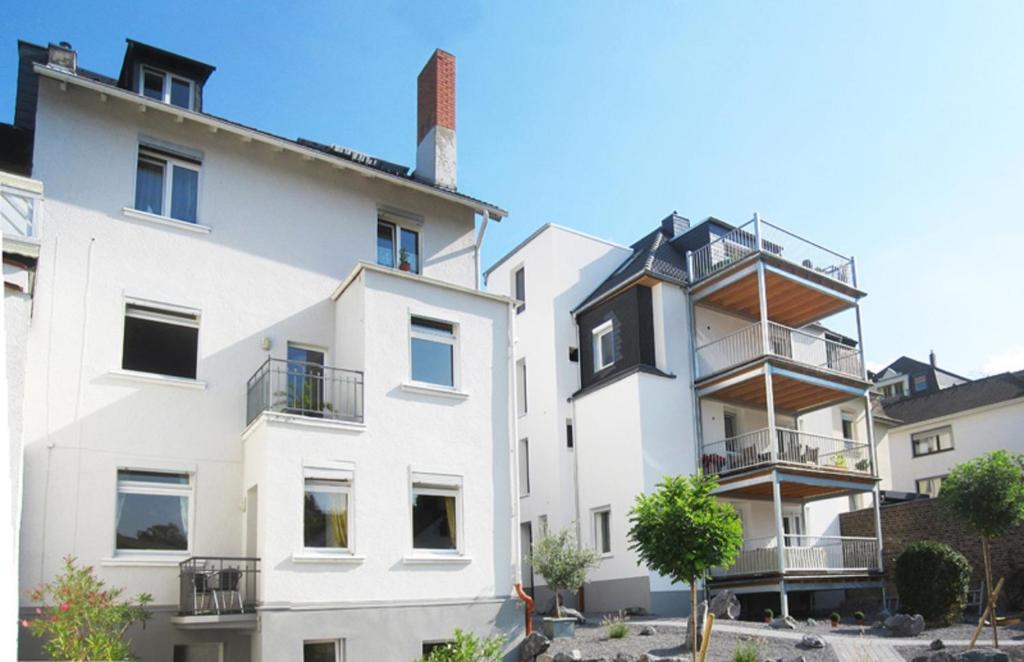 an image of two white buildings with balconies at Ferienwohnungen Nora in Bad Neuenahr-Ahrweiler