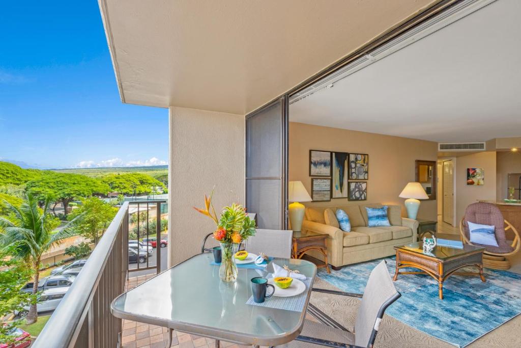 a living room with a balcony with a couch and a table at Kaanapali Shores 422 in Lahaina