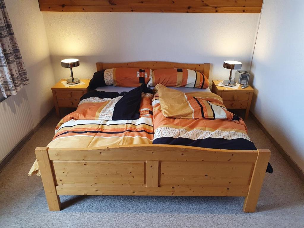 a bed in a bedroom with two lamps on night stands at Chalet Alba A in Bürchen