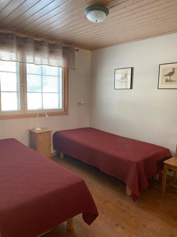 2 Betten in einem Zimmer mit 2 roten Laken in der Unterkunft Levi Kaakkuri 6 in Levi