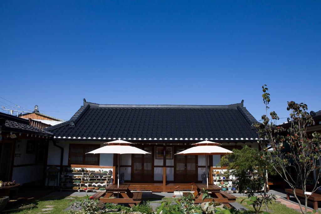 a building with tables and umbrellas in front of it at Hanok Raon in Gyeongju