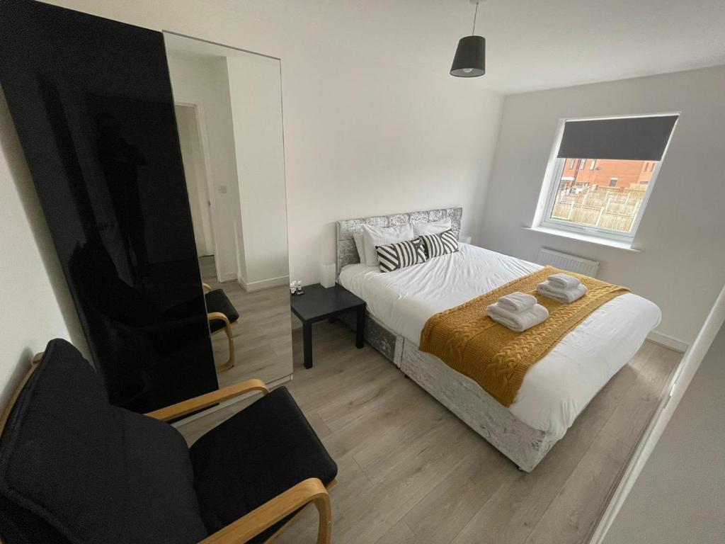a bedroom with a bed and a chair and a window at Modern Room With Huge Bed - Walk to City Centre! in Manchester