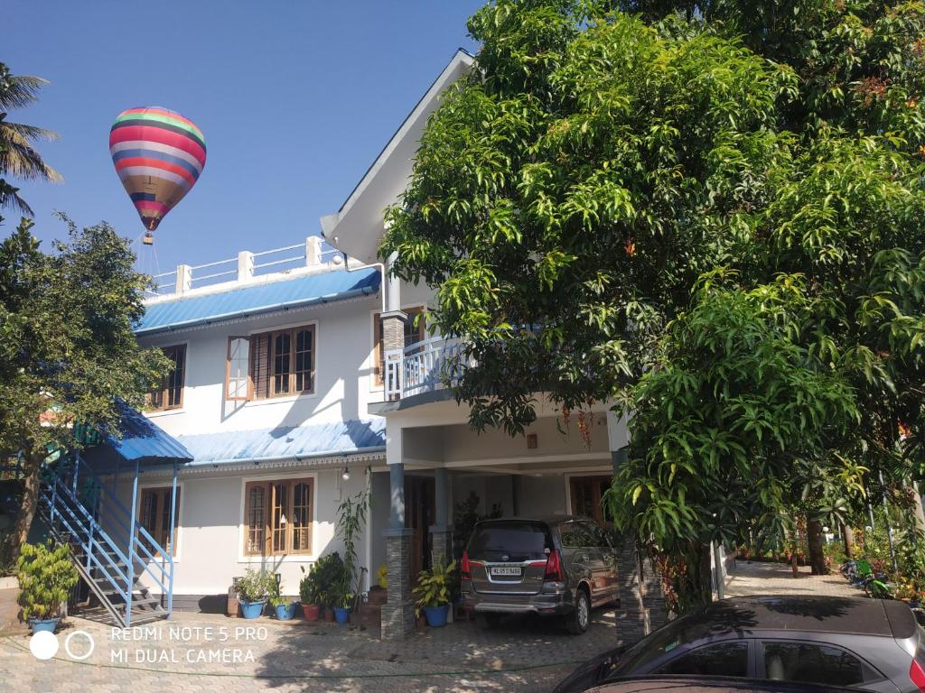 a hot air balloon flying over a house at Munnar Blue Mist in Munnar