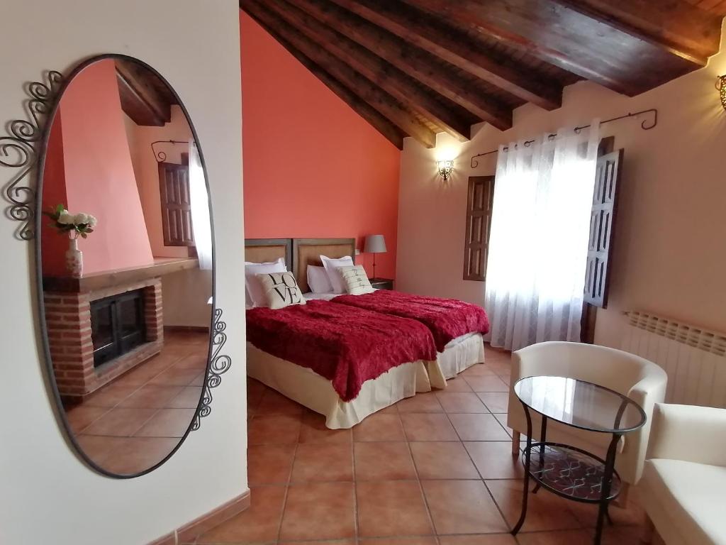1 dormitorio con cama y espejo en La Posada de Horcajuelo en Horcajuelo de la Sierra