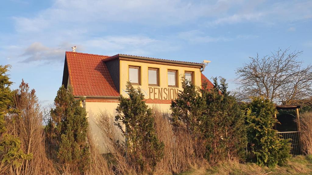 een geel huis met een bord erop bij Pension Küstenkind in Bentwisch
