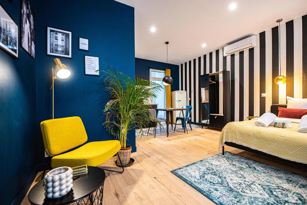 - un salon avec un lit et une chaise jaune dans l'établissement Monsieur Pigalle, à Paris