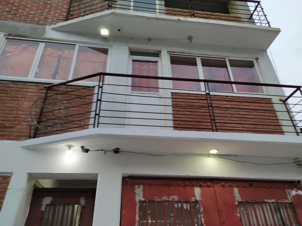 Casa con puerta roja y balcón en Hospedajes Tomas Wilson MX, en Ciudad de México