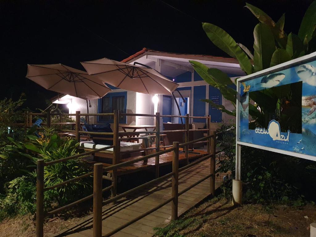 a resort with tables and umbrellas at night at Oceano Azul Noronha in Fernando de Noronha