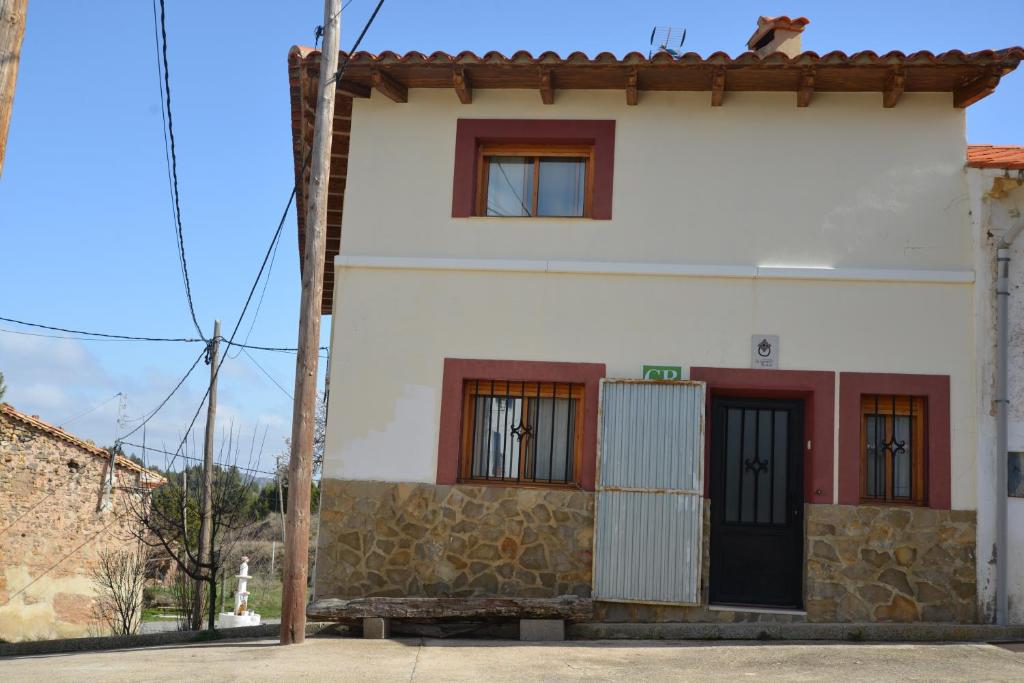 a white house with red windows and a wall at Casa Alhambras in Manzanera
